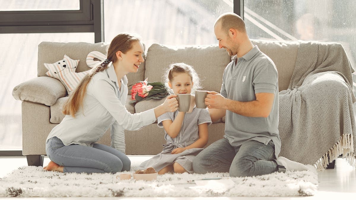 A joyful family enjoying quality time and coffee in a bright living room, symbolizing love and togetherness.